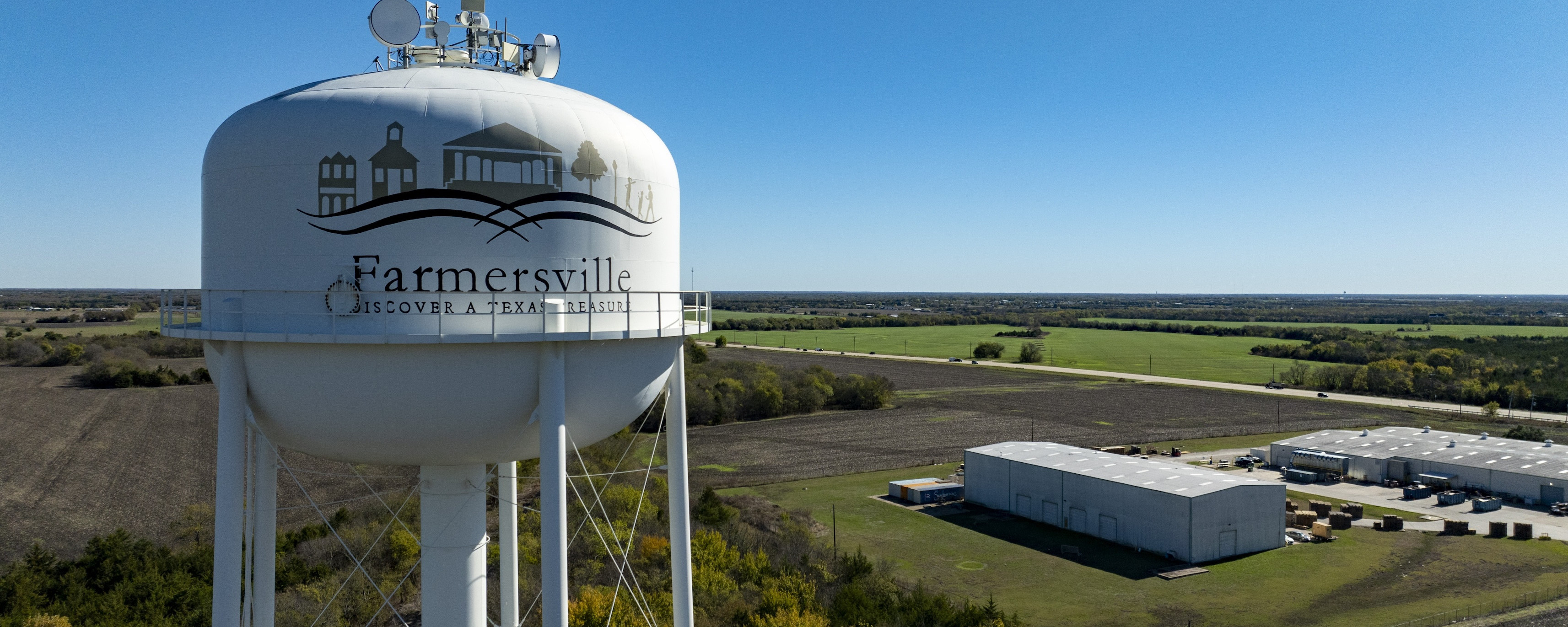 Aerial view of farmersville water tower that reads "Farmersville. Discover a texas treasure"