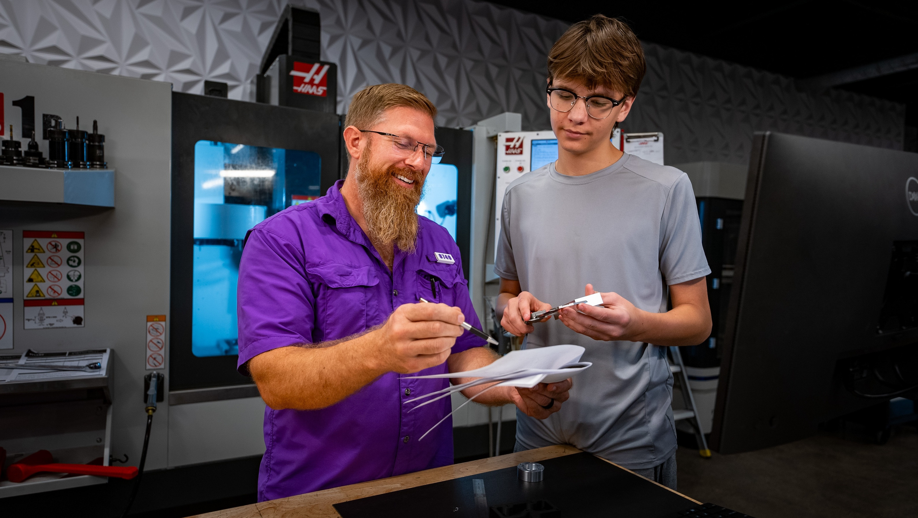 Engineering Teacher with student reviewing papers